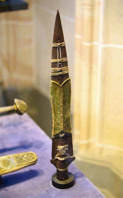 an ornate wooden object on display in a glass case with other items ...