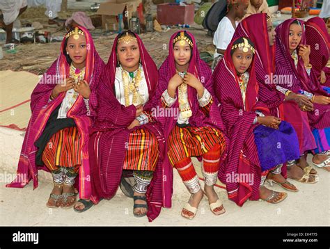 Omani girls in traditional dress take a break during a cultural ...