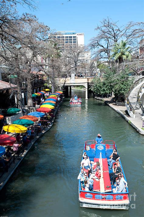 Tourist taking a tour boat ride along the famous riverwalk in downtown San Antonio, Texas ...