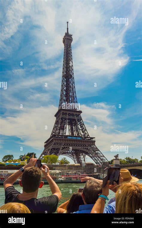 Tourist photographing Eiffel Tower from river cruise boat on Seine ...