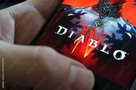 Diablo 4 game logo seen on smartphone hold in a hand. Diablo IV is a ...