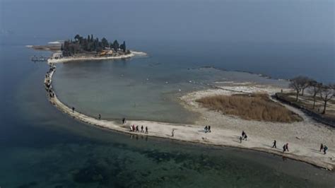 Lake Garda tourists flock to island rejoined by drought