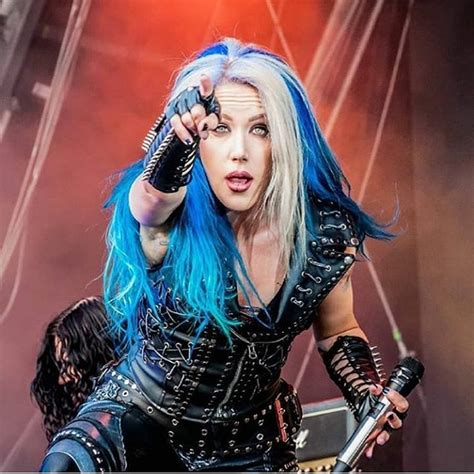 a woman with blue hair and piercings on stage