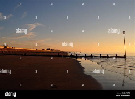 North sea sunset over groins, beach, high tide, Norfolk skies Stock Photo - Alamy