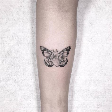 Micro-realistic butterfly heart tattoo on the inner