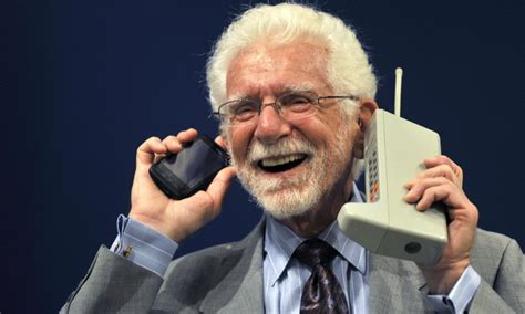 U.S. engineer Martin Cooper holds the Motorola DynaTAC phone, the world ...