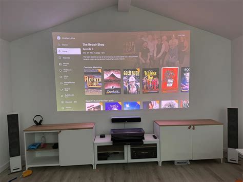 a projector screen in the middle of a room with some speakers on top of it