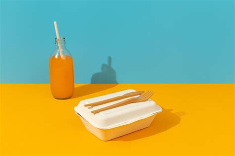 Premium Photo | Lunchbox cutlery and drink on orange table Food delivery concept