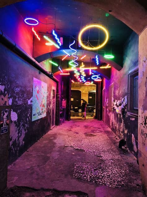 an alleyway with neon lights and graffiti on the walls