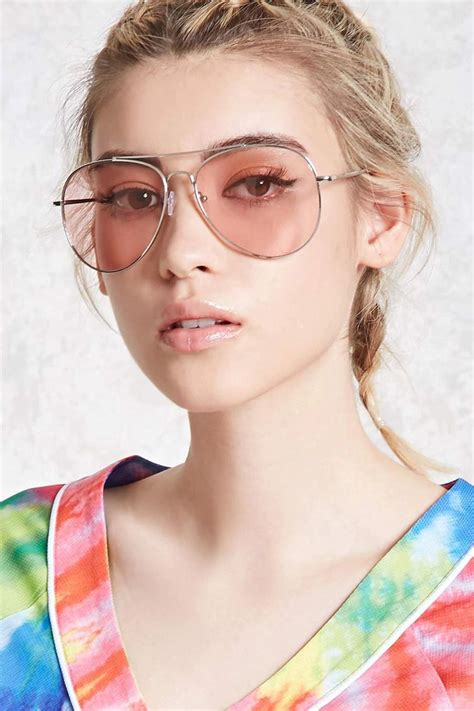 A pair of aviator sunglasses featuring neon tinted lenses, high-polish frames, and a brow bar ...