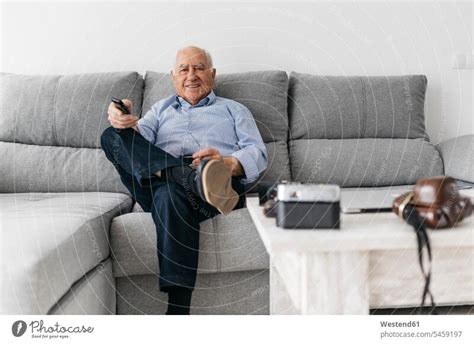 Senior man watching TV from the couch at home - a Royalty Free Stock ...