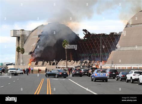 TUSTIN, CALIFORNIA - 7 NOV 2023: Crowd gathers to watch the MCAS Tustin Blimp Hangar on fire ...