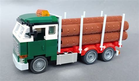 the toy truck is made out of legos and has logs on it's flatbed