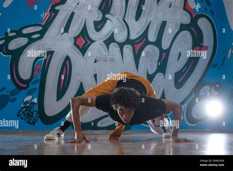 African American hip hop dancer (breakdancer) performing over graffiti ...