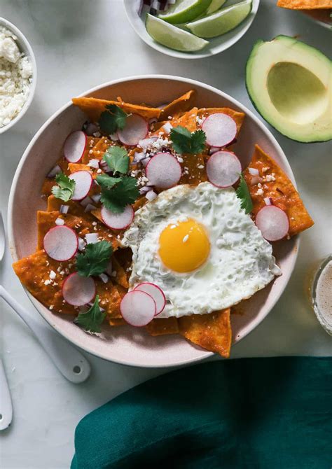 a bowl filled with food on top of a table next to utensils and spoons