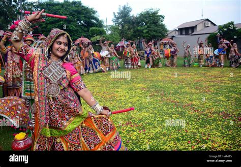 Girls in traditional dress dancing Dandiya Raas Garba traditional folk ...