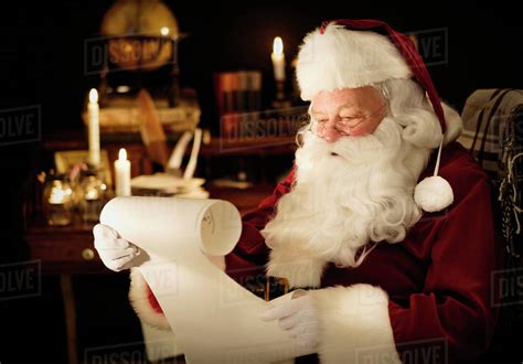 Portrait of Santa Claus reading child's letter - Stock Photo - Dissolve