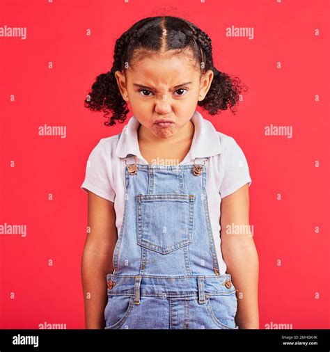 Child, portrait or angry face on isolated red background in emoji tantrum, behavior or stubborn ...