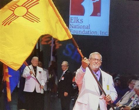 NMEA President Jerry Hitchcock carrying the New Mexico flag across the stage during the 157th ...