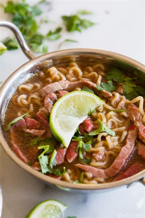 a close up of a bowl of food with noodles and meat on the side ...