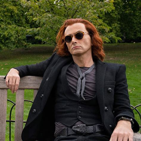 a man with red hair and sunglasses sitting on a bench in the park ...