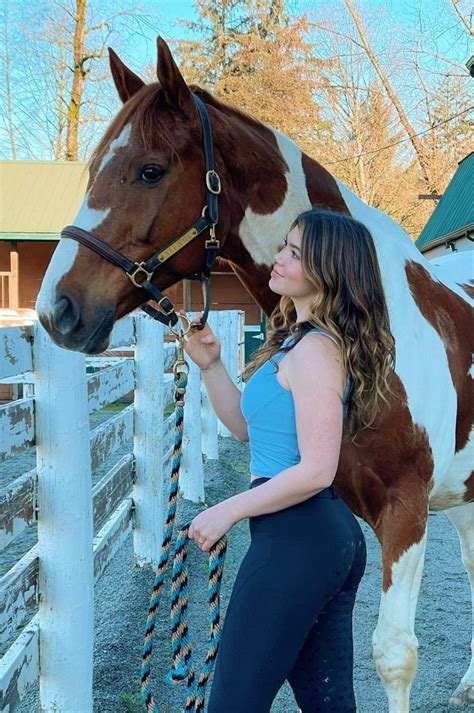 a beautiful young woman standing next to a brown and white horse in a ...