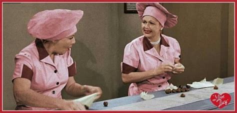 two women in pink scrubs are sitting at a table and one is holding a ...