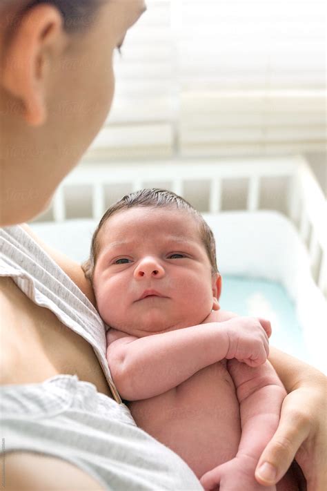 "Young Mother Holding Her Newborn Baby In Her Arms Looking At Him" by Stocksy Contributor "ACALU ...