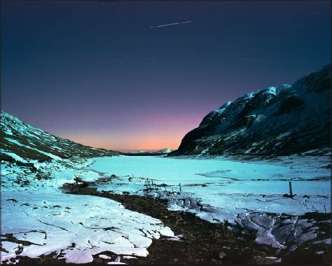 the mountains are covered in snow at night