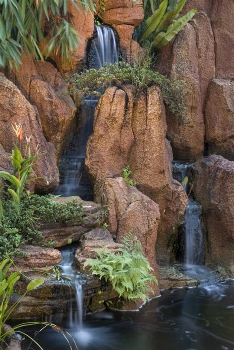 The steep cascades of this garden waterfall fall into two streams, creating a symphony. Ferns ...