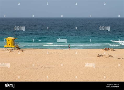 Tourists enjoy a hot summer weather at the crystal clear turquoise waters of Corralejo Beach ...