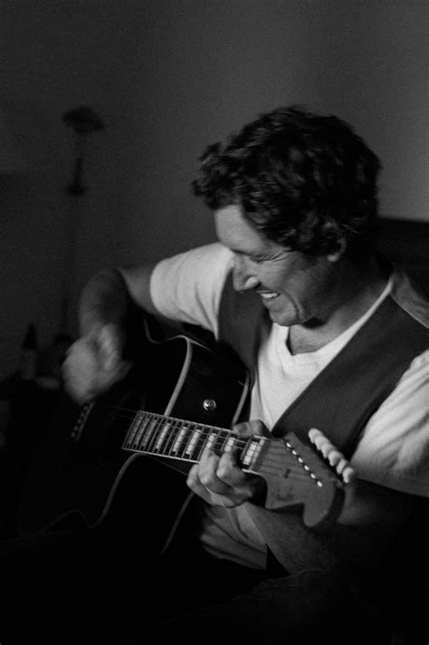 A man playing guitar in a blurred motion black and white photo edited ...