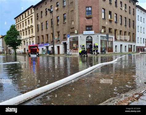 Eberswalde, Germany. 13th June, 2020. The fire brigade uses hoses to pump water from a road ...