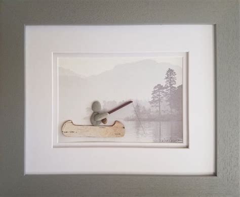 a framed photograph of a man in a canoe