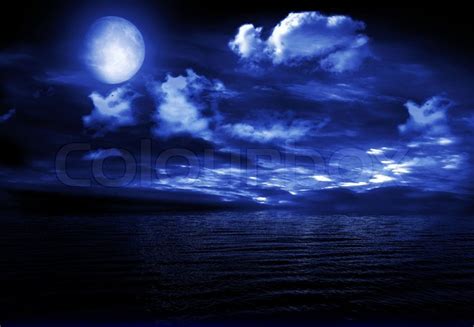 The full moon in the night sky reflected in water | Stock Photo | Colourbox