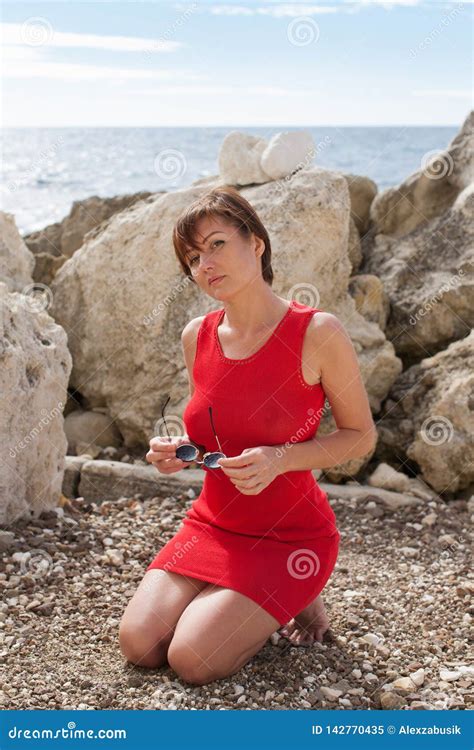 Portrait of Kneeling Woman Outdoors Stock Image - Image of holding, early: 142770435