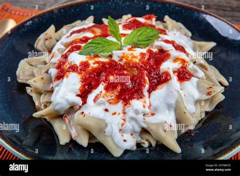 Plates of traditional Turkish food. Turkish Ravioli (Mantı) with yoghurt and tomato sauce Stock ...