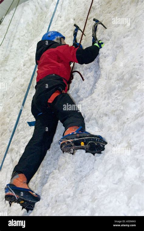 Female ascending an ice climbing wall at the Ice Factor Climbing Centre in Kinlochleven Scotland ...