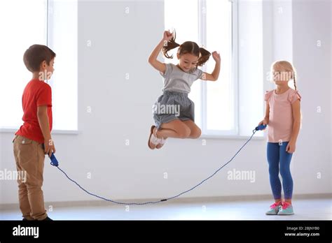 Adorable children skipping rope indoors Stock Photo - Alamy