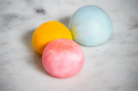 three different colored candies on a marble surface