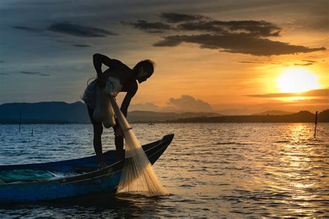 Man on Boat Holding White Mesh Fishing Net · Free Stock Photo