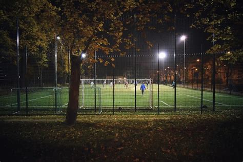 Premium Photo | Soccer players playing football on field at night