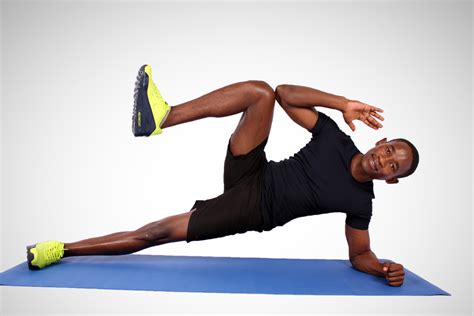Fit Man Doing Side Plank with Knee Crunch on Yoga Mat. Side Plank Crunch Exercise - High Quality ...