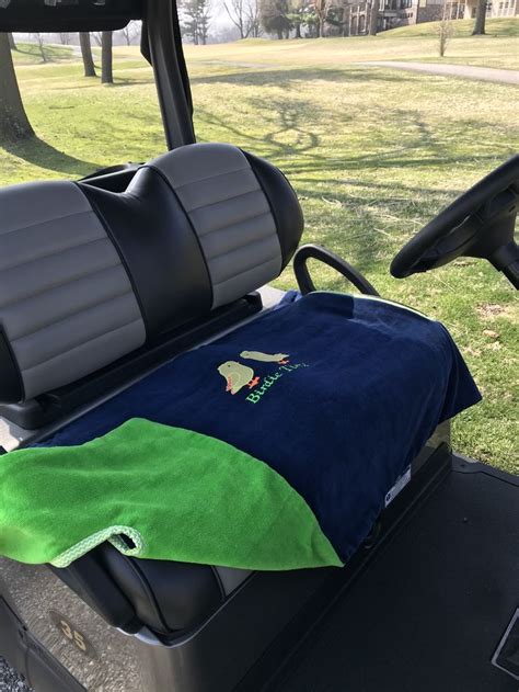 the back seat of a golf cart with a towel on it and a green blanket