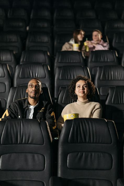 A Couple Sitting on Leather Seats on a Movie Theater · Free Stock Photo