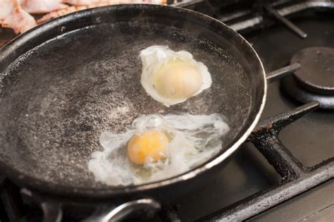 Two eggs being poached in boiling water - Free Stock Image