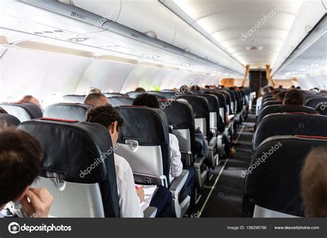 Interior of large commercial airplane with passengers on their seats ...