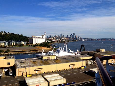 there is a boat docked at the dock in front of some buildings and blue sky