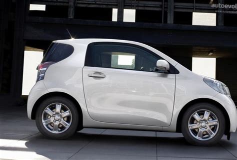 a small white car parked in front of a building