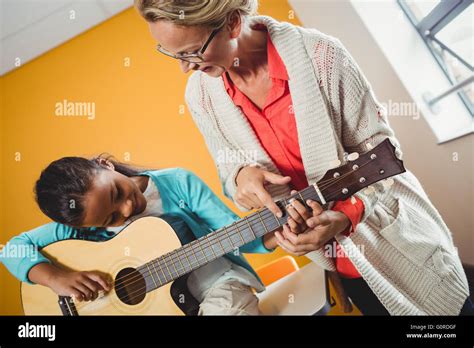 Girl learning how to play the guitar Stock Photo - Alamy